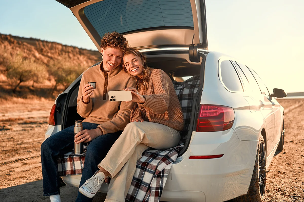 A couple sitting in an open car trunk, part of a local group fundraising with Diamond Express Auto Wash